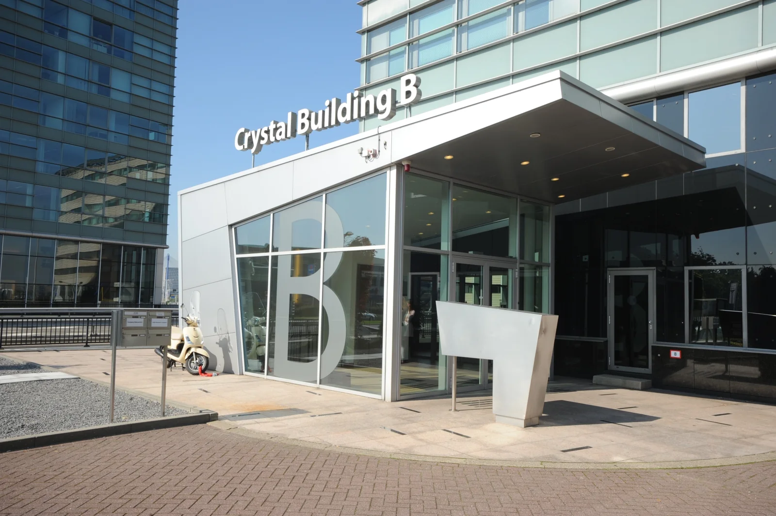 Ingang van het Crystal Building B aan de Rivium Boulevard met moderne architectuur en glazen gevel.